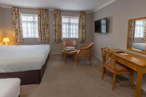 a hotel room with a bed and a desk and a desk at Kings Court Hotel Alcester, BW Signature Collection in Stratford-upon-Avon