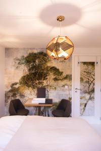 a bedroom with a bed and a desk with chairs at Table Rase chambres d'hôtes, restaurant et weekend aux Thermes de Spa in Theux
