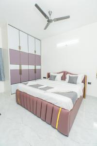 a large bed in a room with a ceiling fan at Aikya Service Apartment in Hyderabad