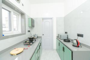 a kitchen with green cabinets and a surfboard on the counter at Aikya Service Apartment in Hyderabad
