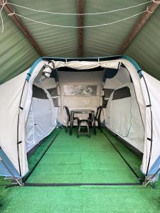 a tent with a table and chairs in it at Ermida Gerês Camping in Ermida +44 photos