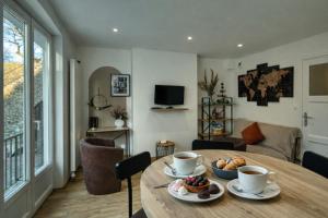 a room with a table with cups and food on it at Au Balcon de la Basilique in Boulogne-sur-Mer