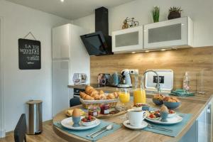 a kitchen with a breakfast table with bread and orange juice at Au Balcon de la Basilique in Boulogne-sur-Mer