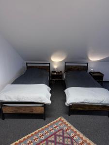 a bedroom with two beds and a rug at Gemütliches City-Appartment in Wentorf bei Hamburg