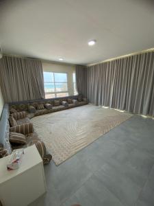 a large living room with couches and a large window at السلع in Sabkhah