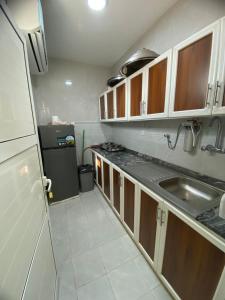 a small kitchen with a sink and a refrigerator at السلع in Sabkhah