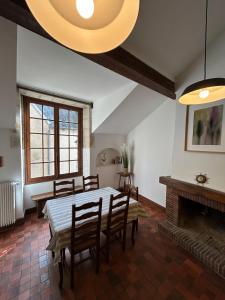 a dining room with a table and chairs and a fireplace at Loft Blois Cathédrale 2 Chambres in Blois