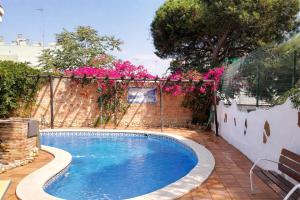 a swimming pool in a yard with pink flowers at Villas con piscina en Punta Umbría by Villamya in Punta Umbría