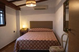 a small bedroom with a bed and a table at Villas con piscina en Punta Umbría by Villamya in Punta Umbría +32 photos