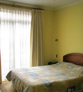 聖地亞哥的住宿－波薩達德爾薩爾瓦多酒店，一间卧室设有一张床和一个大窗户