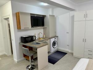 a kitchen with a sink and a washing machine at visitor's house 2 in Rădăuţi