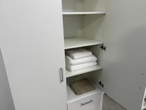 a bathroom with a closet with white towels at visitor's house 2 in Rădăuţi +2 photos