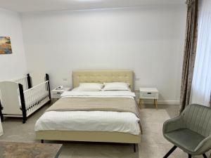 a bedroom with a large bed and a chair at visitor's house 2 in Rădăuţi