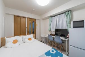 a bedroom with a bed and a desk with a computer at Mary's Room Hakata in Sumiyoshi