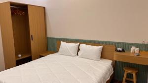 a bedroom with a bed with white sheets and pillows at Chài Beach Homestay in Ninh Hải