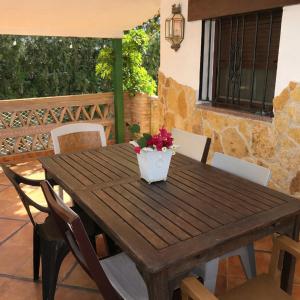a wooden table and chairs on a patio at Villas con piscina en Punta Umbría by Villamya in Punta Umbría