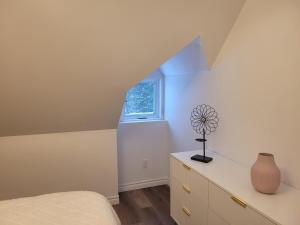a bedroom with a bed and a vase on a dresser at Le Chalet du Domaine Gourmand in Thetford Mines