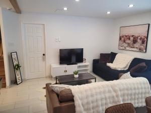 a living room with a couch and a tv at Le Chalet du Domaine Gourmand in Thetford Mines
