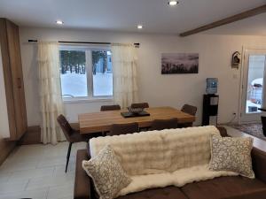 a living room with a couch and a table at Le Chalet du Domaine Gourmand in Thetford Mines