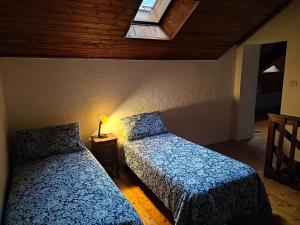 a bedroom with two beds in a room with a window at La Caserma -The Barracks in Bobbio Pellice
