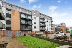 an apartment building with a lawn in front of it at Stylish Flat next2 Wimbledon with a parking in Mitcham Junction