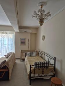 a bedroom with two beds and a chandelier at Sea View Artaki Apartment in Nea Artaki