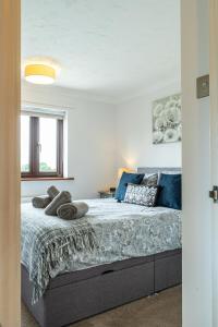 a bedroom with a bed with blue pillows on it at 2 Bedroom Rural Escape In Peaceful Elmswell in Woolpit