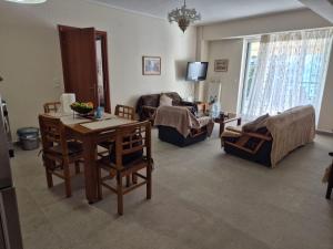 a living room with a table and chairs and a couch at Sea View Artaki Apartment in Nea Artaki