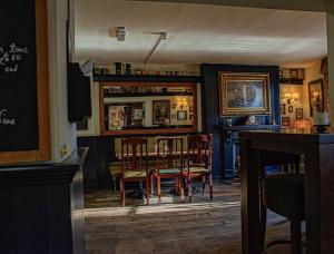 a bar with chairs and a table in a room at The Steam Packet Inn in Totnes