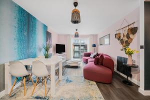 a living room with a table and a red couch at Stylish Flat next2 Wimbledon with a parking in Mitcham Junction