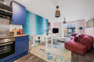a kitchen with a red couch and a living room at Stylish Flat next2 Wimbledon with a parking in Mitcham Junction