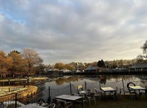 a lake with tables and chairs next to a fence at The Steam Packet Inn in Totnes