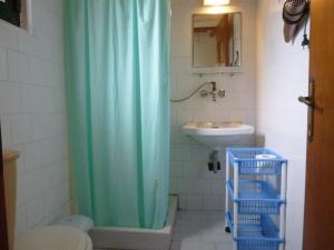 y baño con cortina de ducha y lavamanos. en Athina Apartments en Arillas
