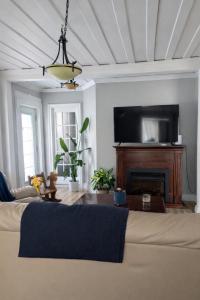 a living room with a couch and a flat screen tv at La belle ancestrale in Sainte-Anne-des-Monts