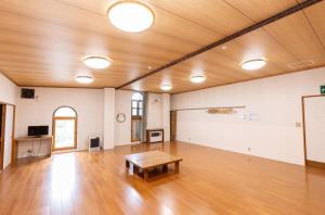 a large room with a wooden floor and a table at 苗場ロッヂ丘 in Yuzawa