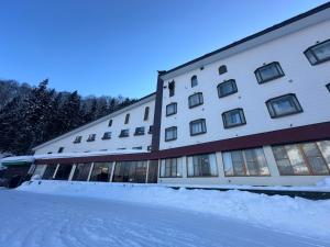 a large building with snow in front of it at 苗場ロッヂ丘 in Yuzawa
