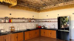 a kitchen with wooden cabinets and black counter tops at Chài Beach Homestay in Ninh Hải