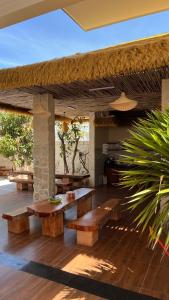 a pavilion with wooden tables and benches on a wooden floor at Chài Beach Homestay in Ninh Hải