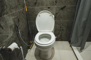 a bathroom with a toilet with a shower curtain at The Southside Den in Āīzawl +12 photos