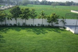a yard with a fence and trees in a field at Rajstar Resort in Murthal +4 photos
