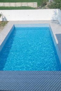 a pool of blue water on a tile floor at Rajstar Resort in Murthal