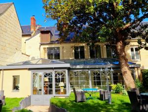 a house with a greenhouse in the yard at L'Hostellerie de La Licorne in Fontevraud-l'Abbaye