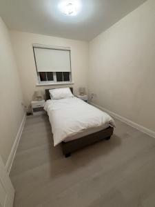 a white bedroom with a bed and a window at Haven at Chafford Hundred in West Thurrock