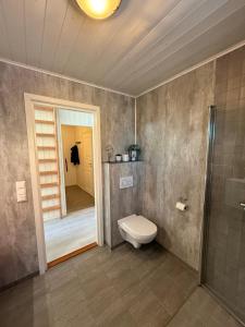 a bathroom with a toilet and a walk in shower at Modern waterfront rorbu with terrace and stunning sea view - free parking in Stamsund +47 photos
