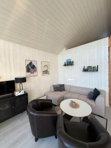 a living room with a couch and a table and chairs at Modern waterfront rorbu with terrace and stunning sea view - free parking in Stamsund
