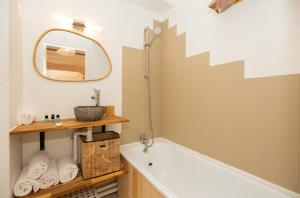 a bathroom with a tub and a mirror at Atlantic Selection - Studio La Sud - Piscine in Hossegor