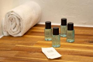 a group of four bottles of nail polish on a wooden floor at Atlantic Selection - Studio La Sud - Piscine in Hossegor