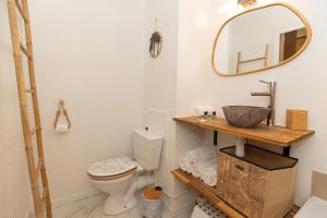 a bathroom with a sink and a toilet and a mirror at Atlantic Selection - Studio La Sud - Piscine in Hossegor