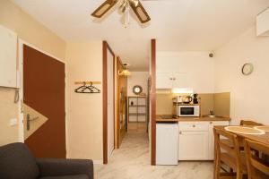 a kitchen with a table and a ceiling fan at Atlantic Selection - Studio La Sud - Piscine in Hossegor +14 photos