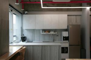 a kitchen with white cabinets and a counter top at Stay PLAN B in Seoul